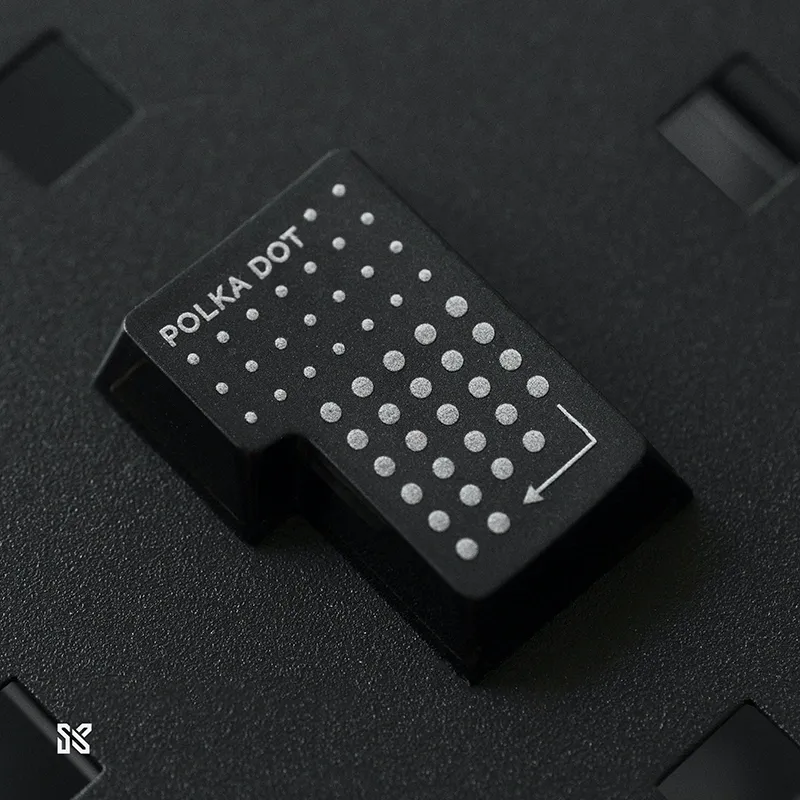 Single black polka dot keycap close-up showing frosted PC material texture and precise dot pattern craftsmanship