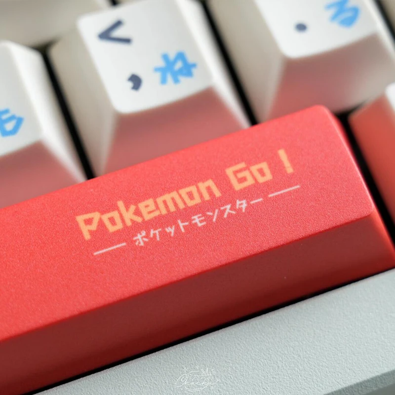 Pokemon Go spacebar keycap with Japanese text in coral color surrounded by white keycaps with blue Japanese characters