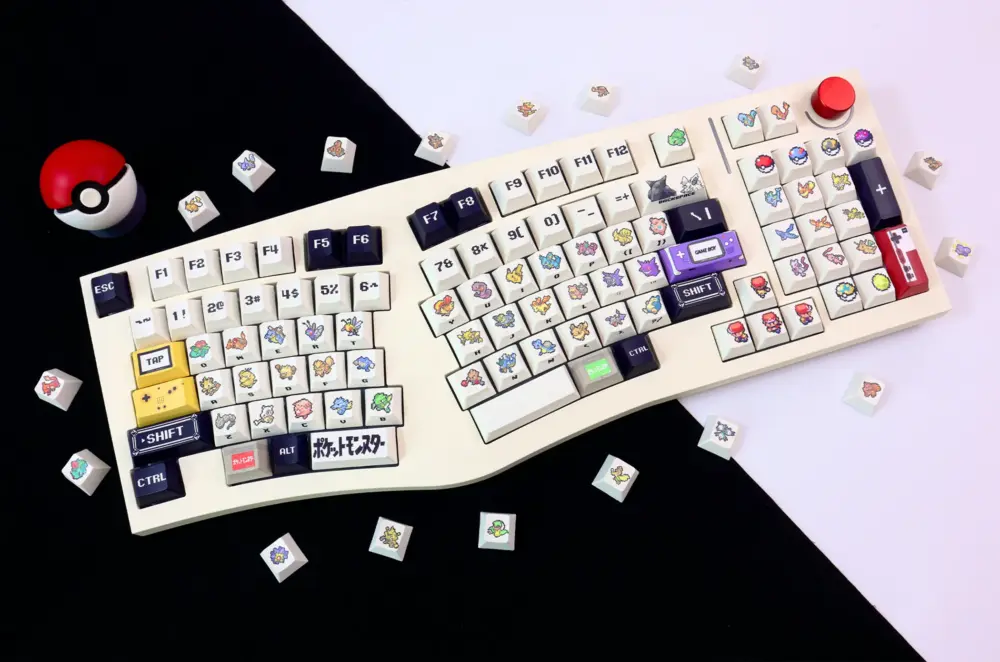 Angled view of Pokemon keycaps on white Alice layout mechanical keyboard with scattered Pokemon character keys and Pokeball