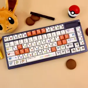 Eevee Cherry Profile PBT Keycaps | Complete Pokémon Gaming Keyboard Set Full keyboard with Eevee pixel art keycaps displayed alongside Eevee plush, Pokeball, and cookies on beige desk surface.