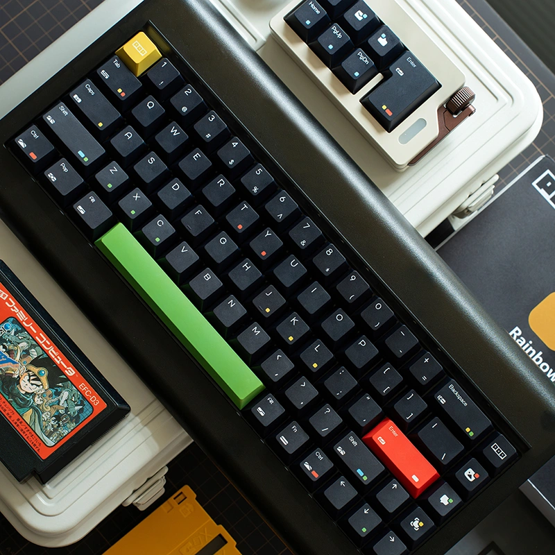 Black mechanical keyboard with green spacebar next to vintage computer on desk