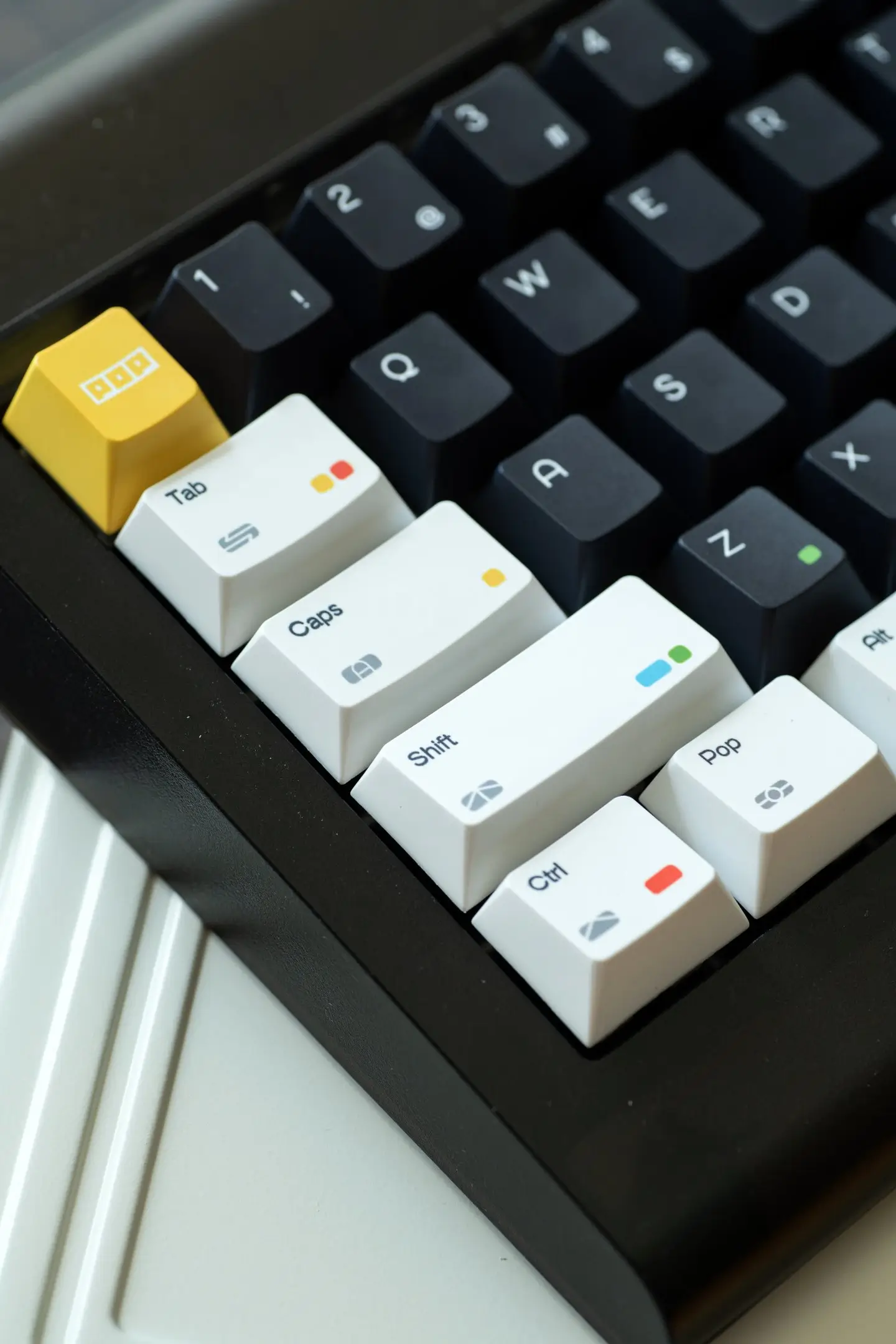 White modifier keys with rainbow dots contrast against black alphas on keyboard