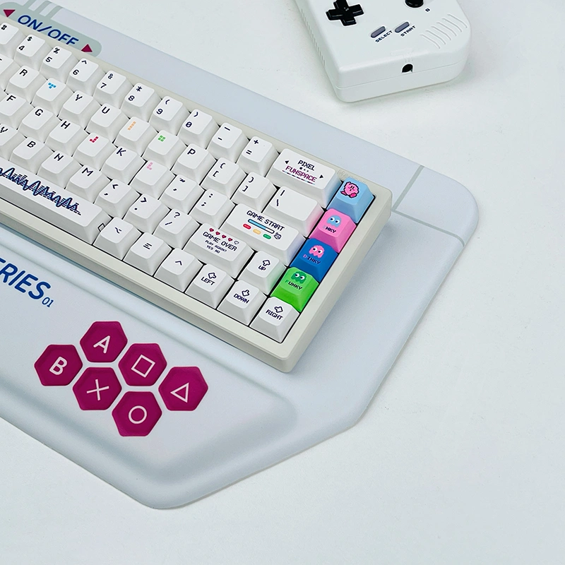 Close-up of hexagonal gaming buttons on white retro console keyboard wrist rest showing A/B/X/Y/O buttons in magenta color.