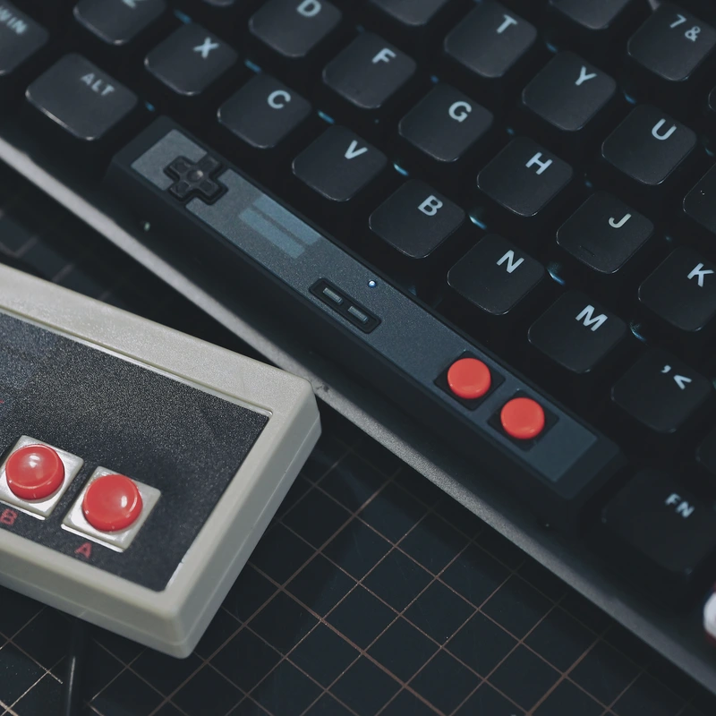 Black controller spacebar on keyboard next to vintage gaming controller, design comparison, retro authenticity