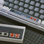 Retro Gaming Spacebar Keycap on a gray mechanical keyboard, showcasing D-pad and red buttons with retro charm.