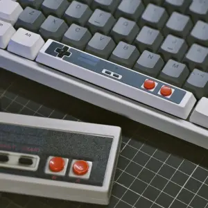 Retro Gaming Spacebar Keycap on a gray mechanical keyboard, showcasing D-pad and red buttons with retro charm.