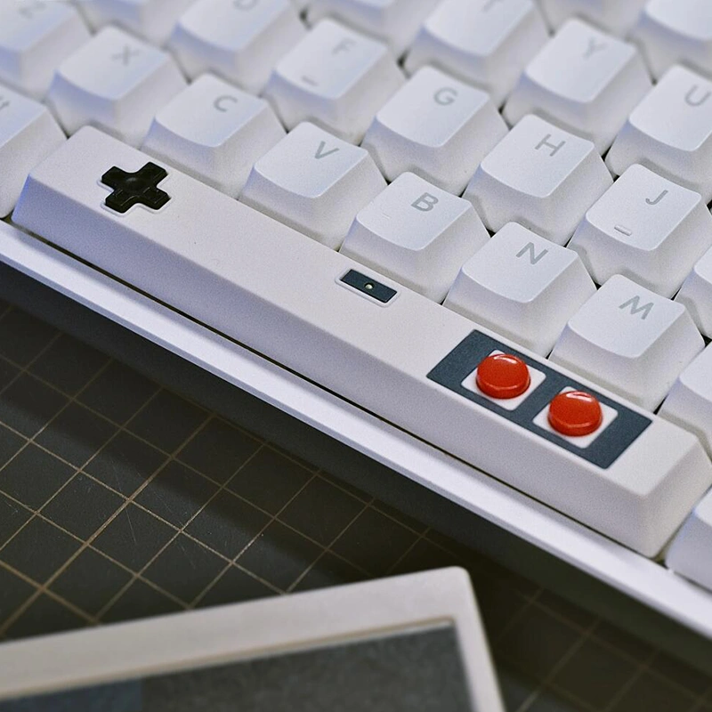 White controller spacebar keycap installed on mechanical keyboard, D-pad and buttons visible, gaming aesthetic