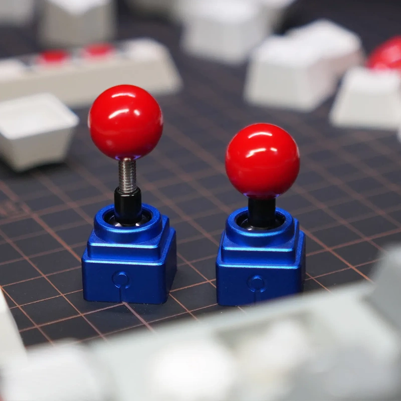Retro Joystick Metal Artisan Keycap | Blue High & Low Profile Versions Two blue metal joystick keycaps with red balls on keyboard, arcade gaming artisan caps, premium aluminum finish
