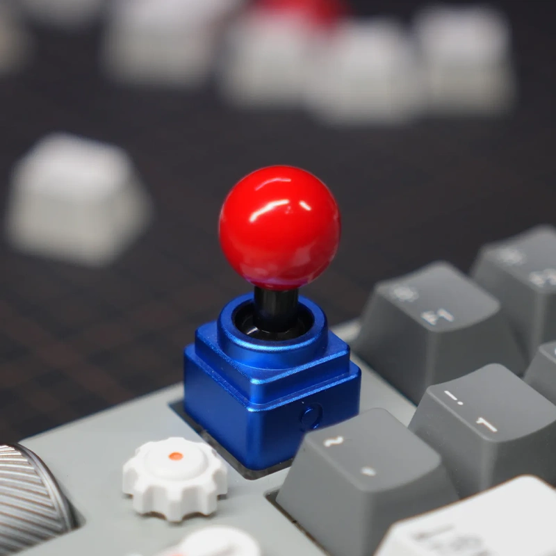 Arcade Joystick Keycap Close-up - Mechanical Tactile Feedback Design Close-up blue joystick artisan keycap on mechanical keyboard showing detailed metal construction and red ball top