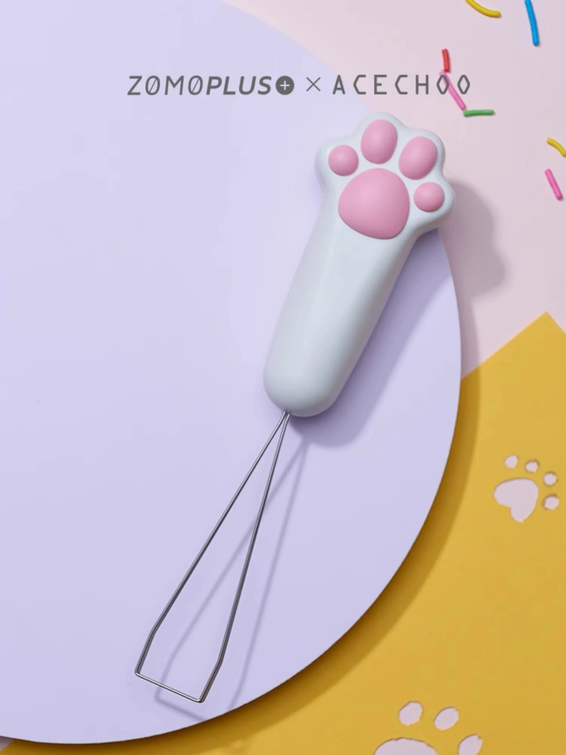 White cat paw keycap puller with pink pads on colorful playful background