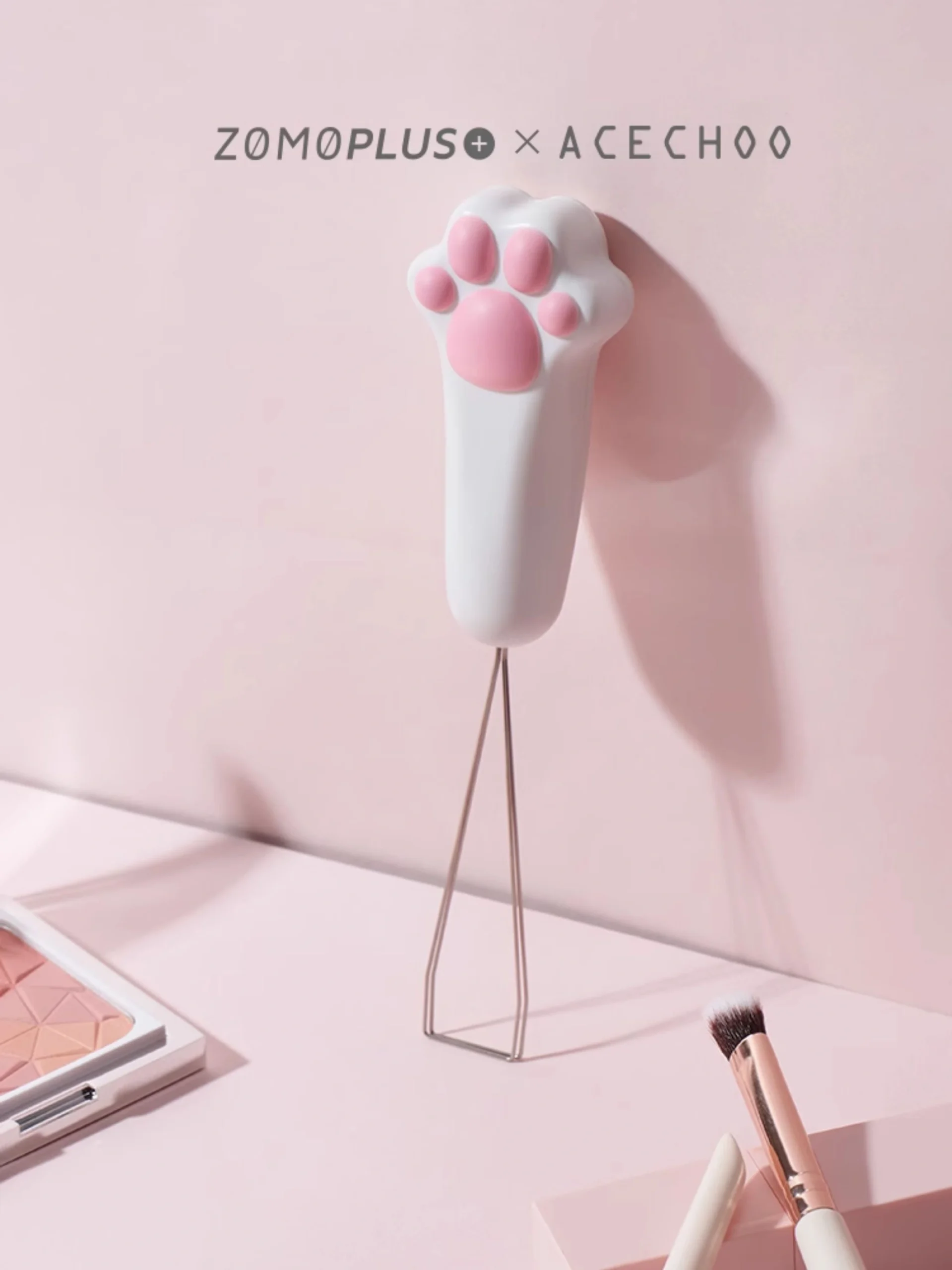 Cat paw keycap puller standing as desk decoration with makeup brushes nearby