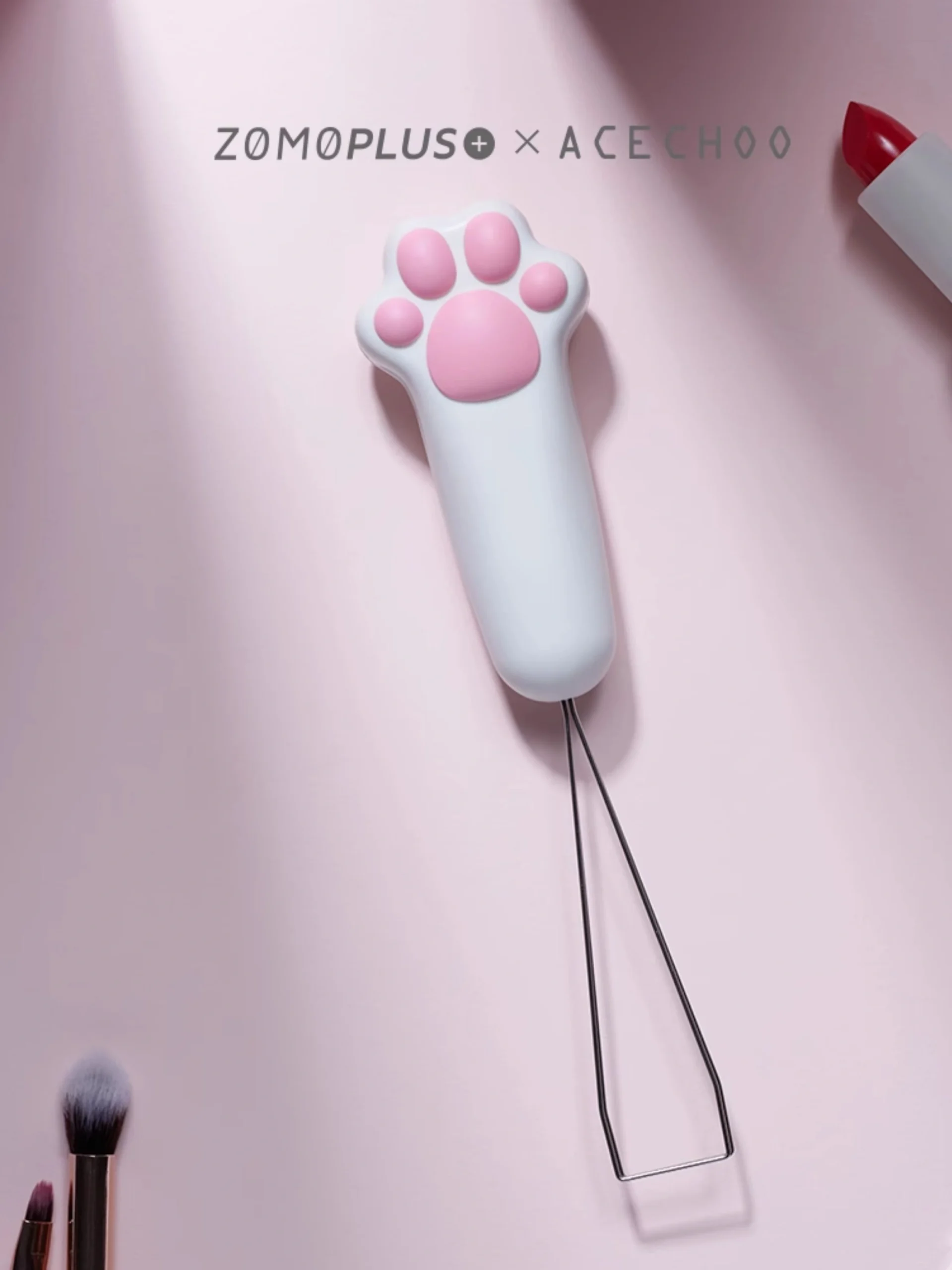 White cat paw keycap puller with pink paw pads on minimalist background