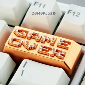 Gold aluminum artisan keycap with Game Over pixel text on white keyboard
