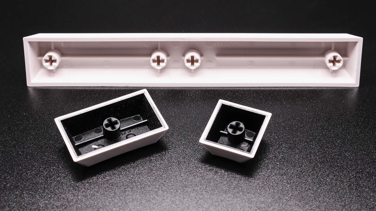 Cherry MX keycaps underside showing cross-shaped stem mounts and stabilizer slots for spacebar compatibility