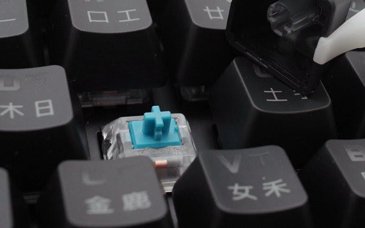 Mechanical keyboard with keycap removed exposing Cherry MX compatible switch cross stem for compatibility verification
