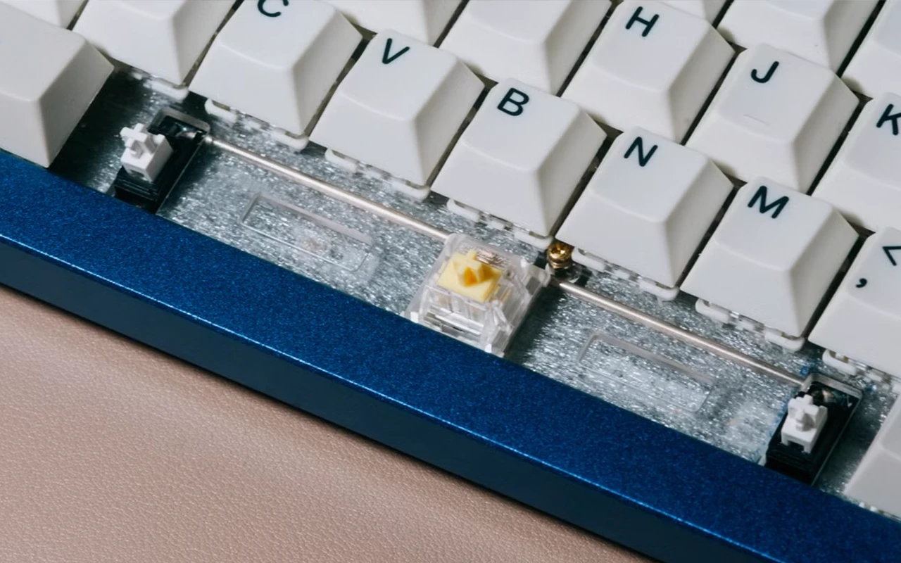 Keyboard spacebar with stabilizer wire preventing tilt when pressed off center