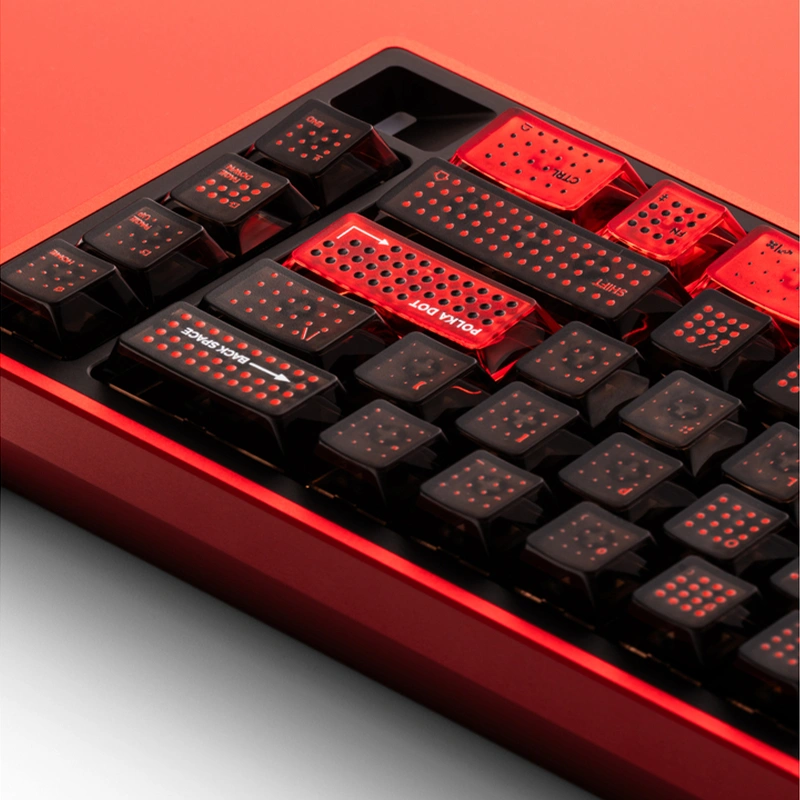 Corner view showing red accent keycaps with raised polka dot pattern detail