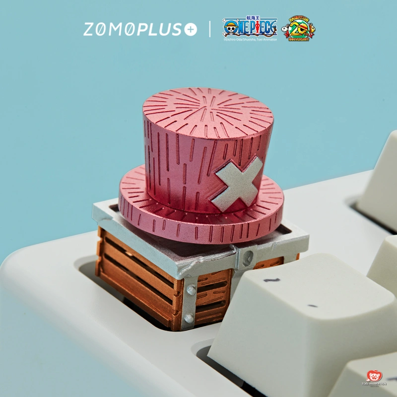 One Piece Chopper rotating hat keycap in pink aluminum mounted on white keyboard against blue background