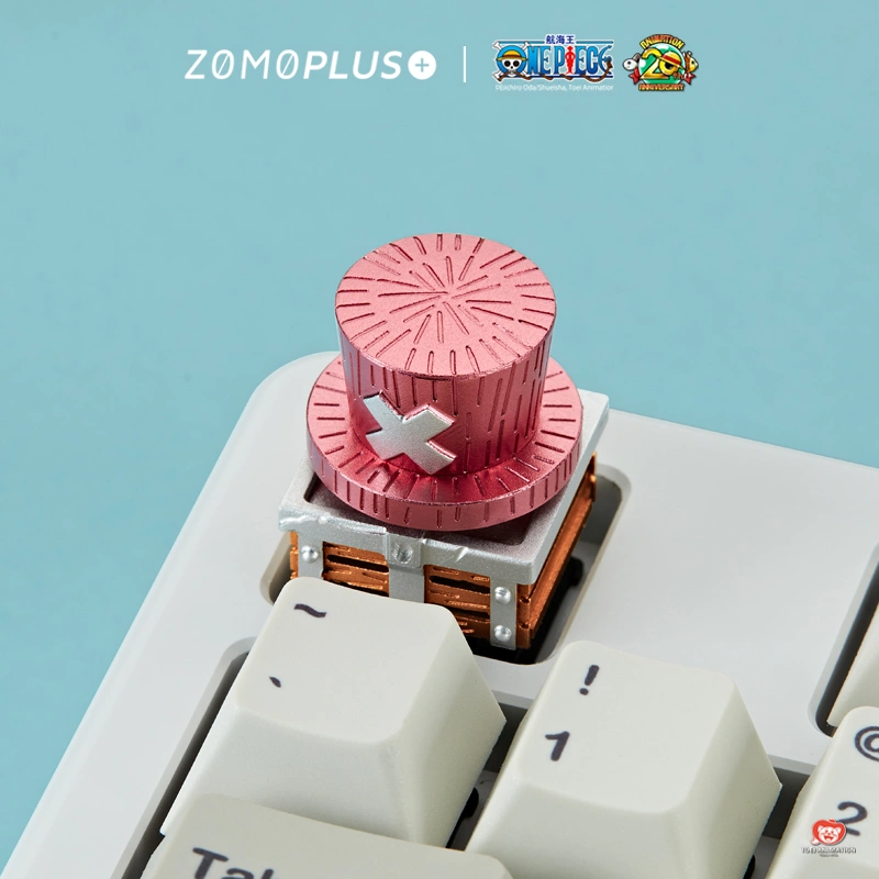 Side view of Chopper pink hat aluminum keycap on keyboard showing layered hat design and wooden base details