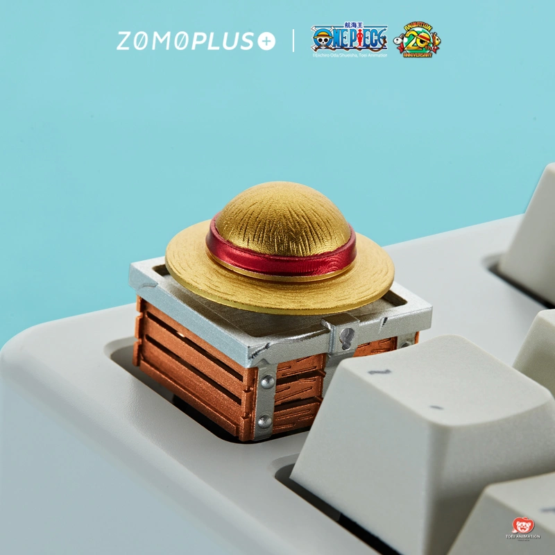 Gold straw hat keycap with red ribbon on wooden treasure chest detail