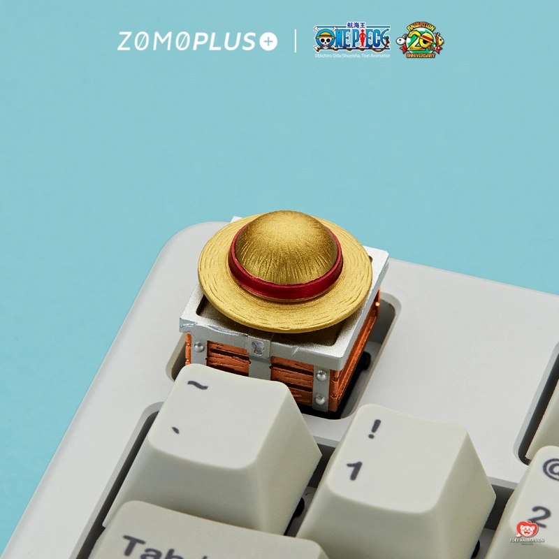 Luffy's iconic straw hat aluminum keycap on treasure chest angled view