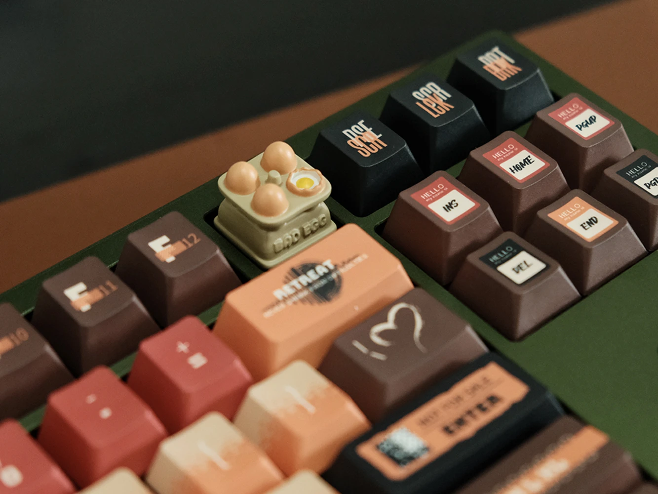 Close-up of egg tray artisan keycap on green mechanical keyboard showing hand-painted miniature eggs with yolk among colorful keys