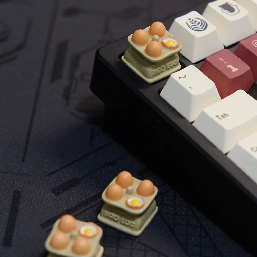 Close-up of egg tray artisan keycap mounted on mechanical keyboard showing hand-painted miniature eggs with yolk detail