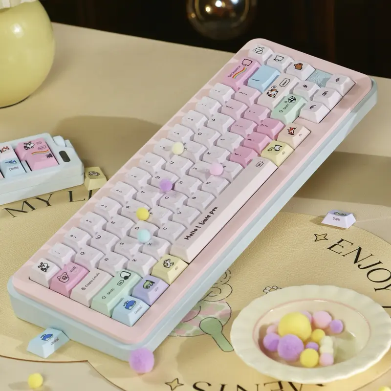 Pink Keycaps with pastel colors and animal illustrations on a mechanical keyboard with decorative pom poms.