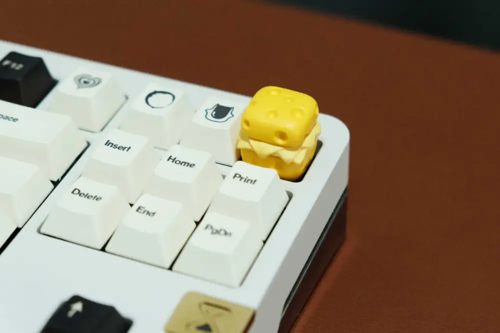 Cute Cheese Artisan Keycap Installed Side view of cute cheese 3D printed artisan keycap on a keyboard with white keycaps.