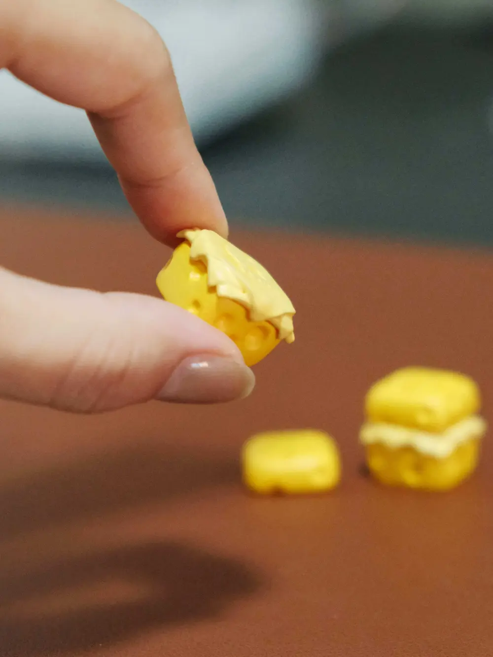 Detachable Magnetic Cheese Keycap Top Fingers holding the detachable yellow resin top of a 3D printed cheese keycap.