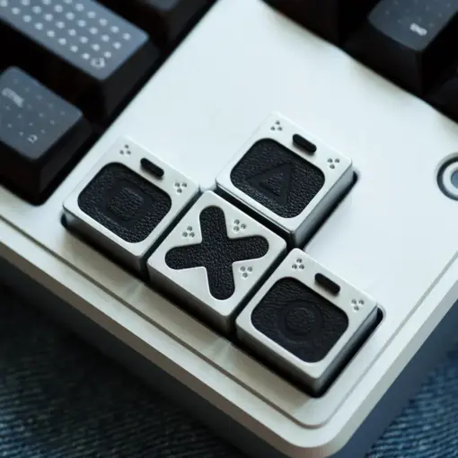 Genuine leather PlayStation keycaps installed on a keyboard showing triangle, square, circle, and cross symbols.