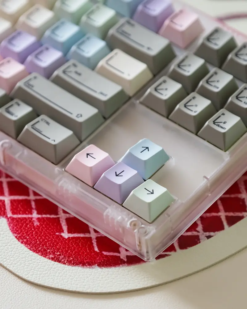 Detail shot of SINOKEY pastel keycaps showing line art legends on colorful arrow keys.