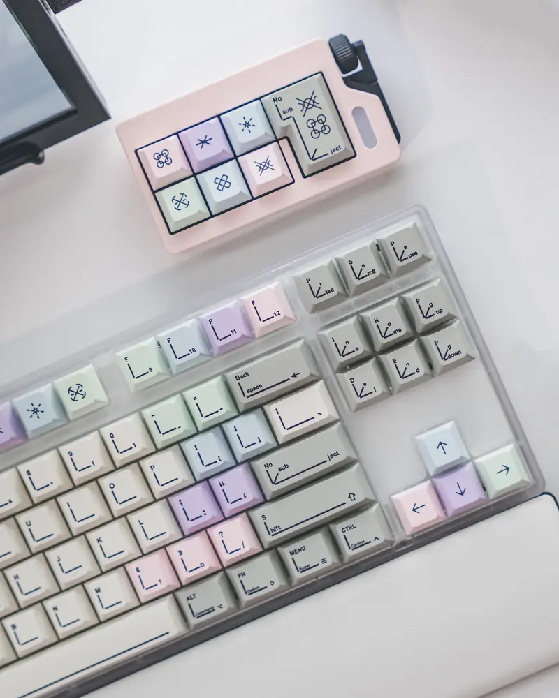 Overhead view of Pastel Keycaps installed on a mechanical keyboard and macro pad with geometric symbols.