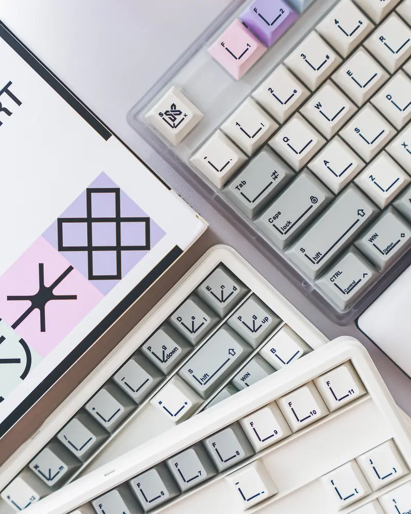 Top-down view of Pastel Keycaps featuring minimalist line art legends and grey, white, and pink tones.