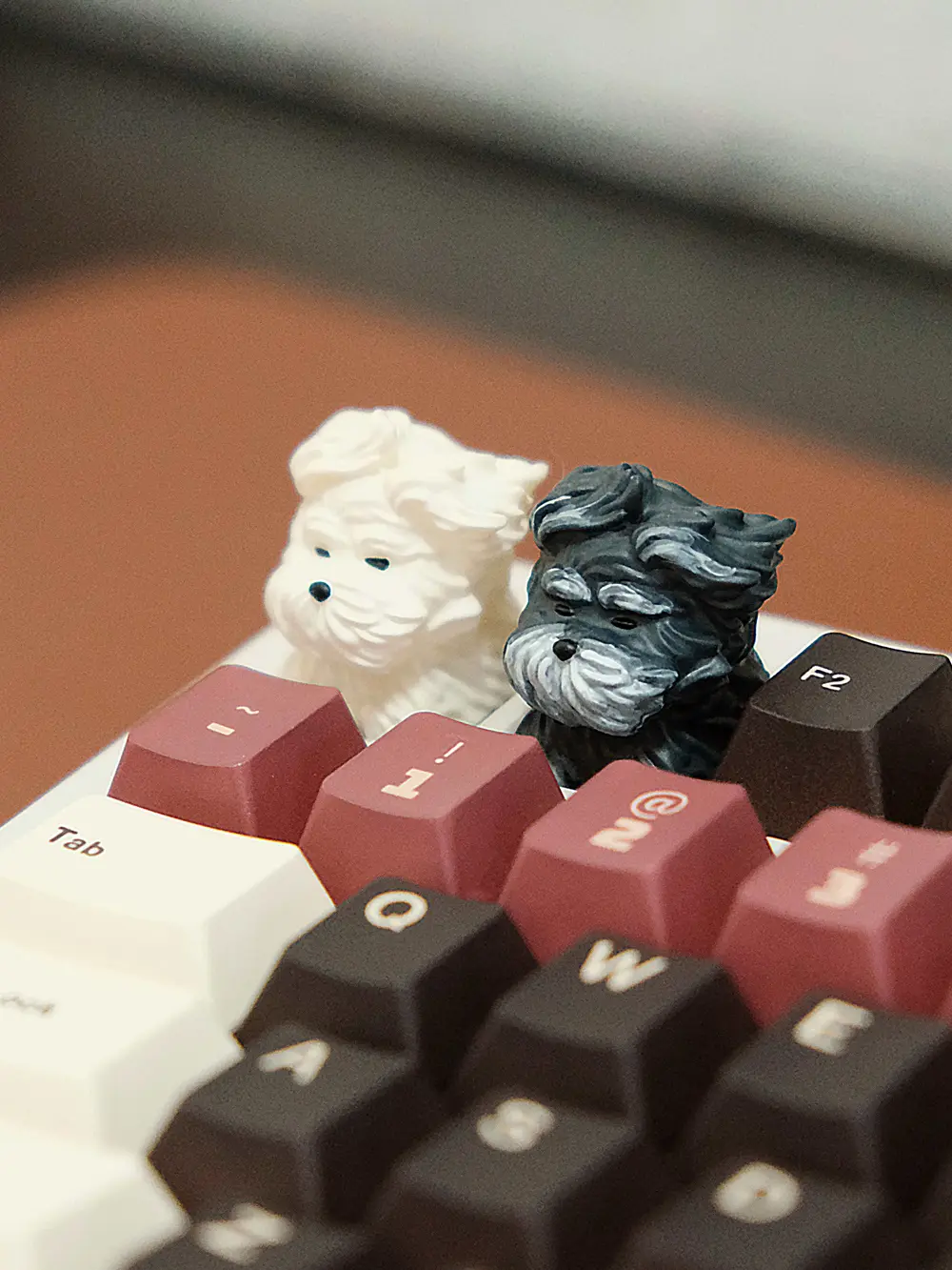 Close-up of 3D printed cute puppy keycaps in white and black with detailed fur texture.
