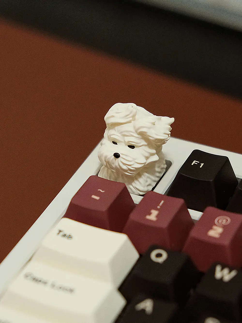 White resin artisan keycap shaped like a wind-blown puppy head installed on a mechanical keyboard.