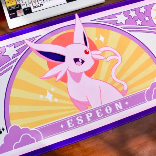 Pokemon Espeon large gaming desk mat on a desk next to a mechanical keyboard and figures.