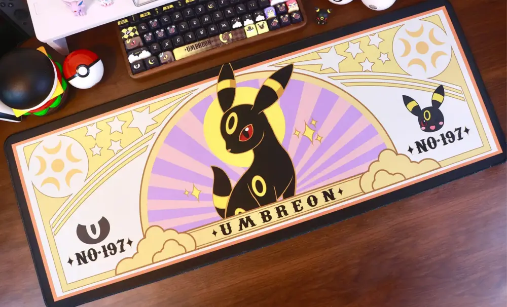 Pokemon Umbreon gaming desk mat with purple and yellow celestial design on a wooden desk.