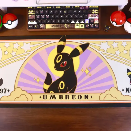 Pokemon Umbreon gaming desk mat centered on a desk with a custom keyboard, game controller, and Poke Balls.