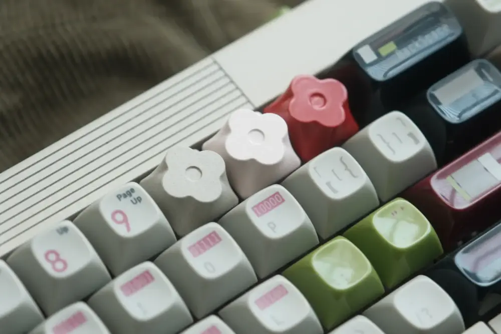 Close-up of red, white, and gray flower metal artisan keycaps precision-milled from aluminum alloy on a keyboard.