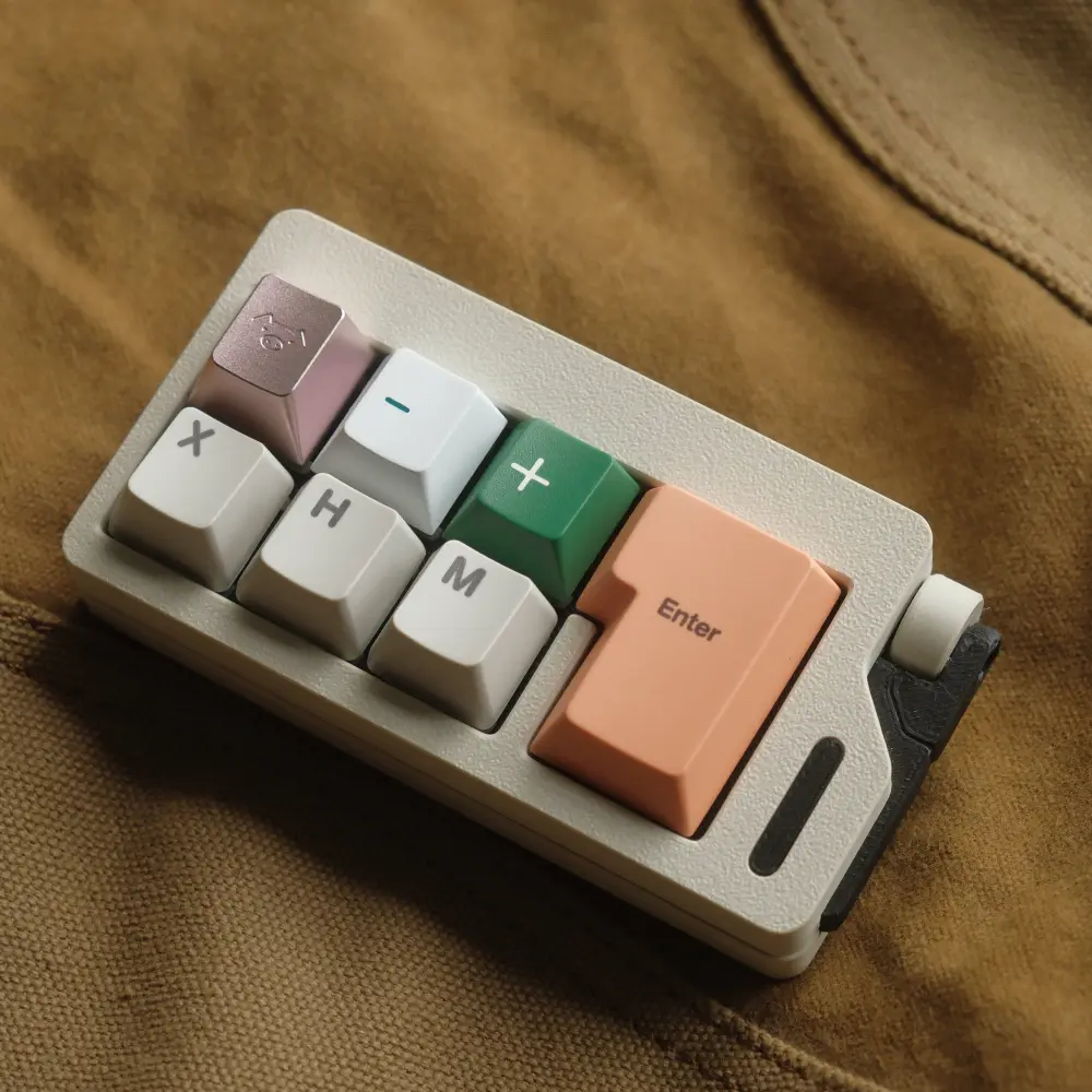 Close-up of a blush pink CNC aluminum keycap featuring a cute pig engraving on a small keyboard pad.