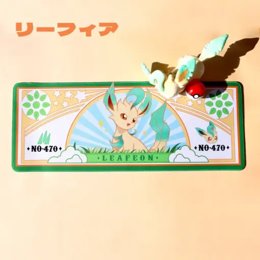 Overhead view of the Pokemon Leafeon large gaming desk mat showing a grass-type design with a plush toy.