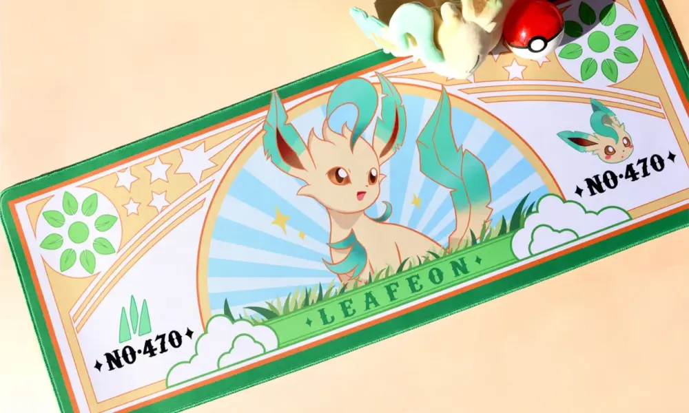 Top-down view of a Pokemon Leafeon large gaming desk mat with vibrant nature graphics and green stitched edges.