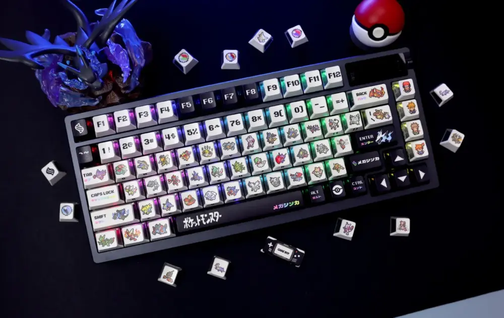 Illuminated Pokemon Mega Evolution Keycaps on a dark mechanical keyboard with a Poke Ball and scattered keys.