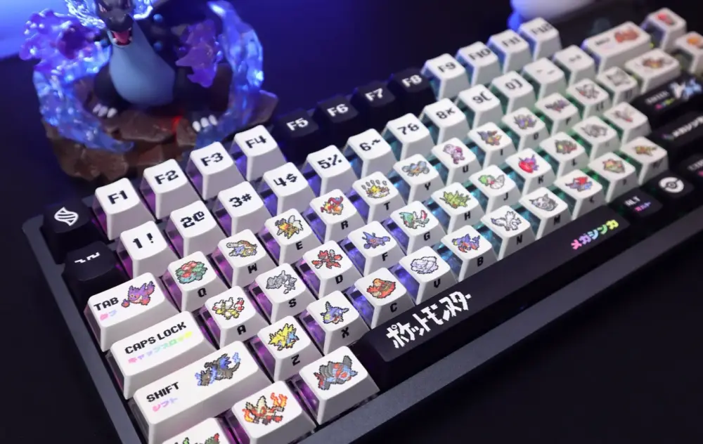 Close-up of custom Pokemon keycaps with Mega Evolution pixel art and translucent sides on a mechanical keyboard.