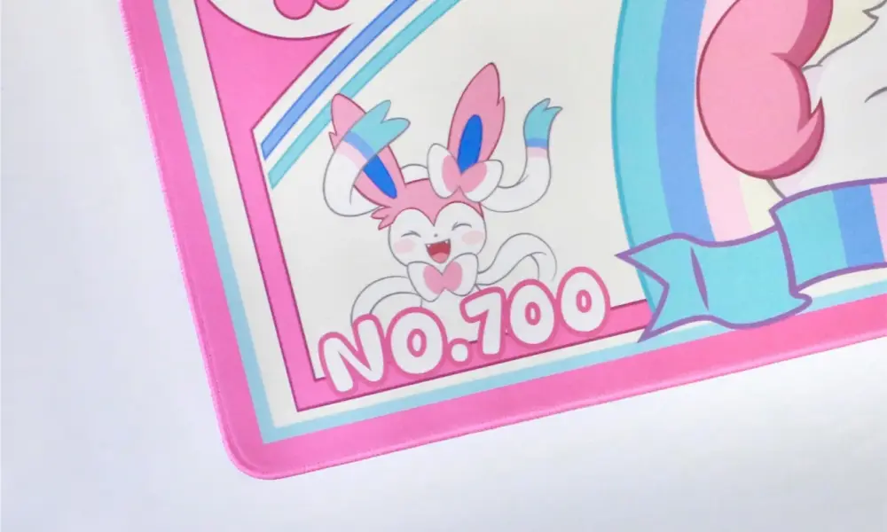 Close-up of the Sylveon gaming desk mat showing pink stitched edges, a small Sylveon, and NO.700 text.