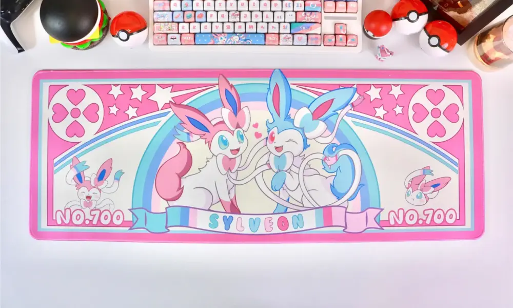 Large gaming desk mat with Sylveon artwork, matching mechanical keyboard, and Pokéball accessories.