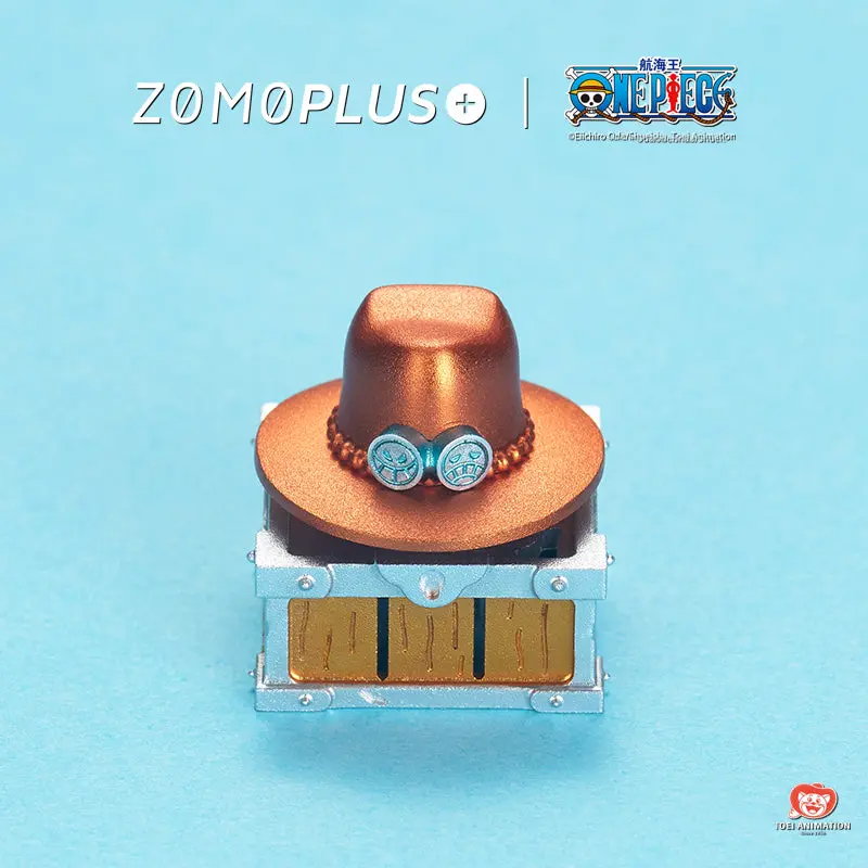 ZOMOPLUS One Piece Ace’s Hat Rotating Aluminum Artisan Keycap ZOMOPLUS One Piece Ace Hat artisan keycap featuring the orange hat with blue medallions on a treasure chest base.