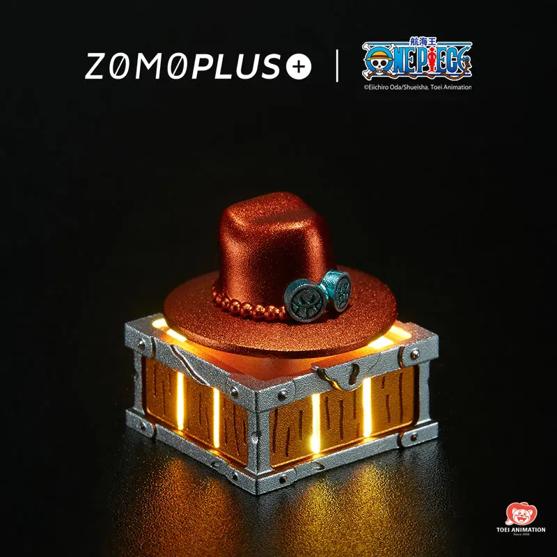 ZOMOPLUS One Piece Ace’s Hat Rotating Aluminum Artisan Keycap ZOMOPLUS One Piece Ace's hat artisan keycap on a treasure chest base with internal warm lighting.