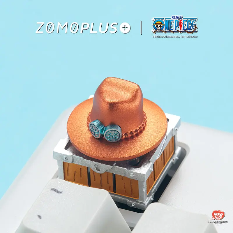 ZOMOPLUS One Piece artisan keycap featuring Ace's orange hat with blue badges on a treasure chest base.
